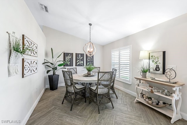 dining room with parquet floors and a chandelier