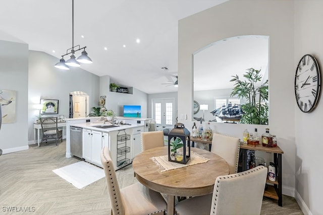 dining room featuring light parquet flooring, lofted ceiling, sink, and french doors