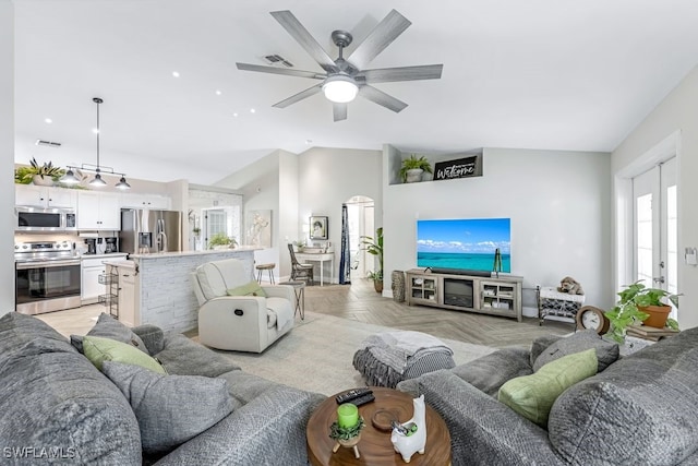 living room featuring ceiling fan, lofted ceiling, and light parquet floors