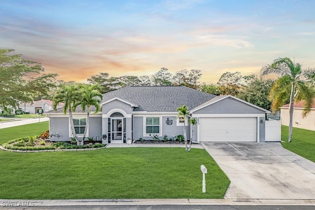 single story home with a lawn and a garage