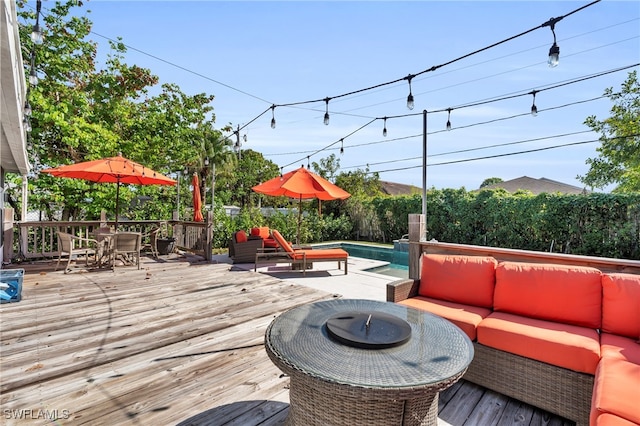 wooden terrace featuring outdoor lounge area and a fenced in pool