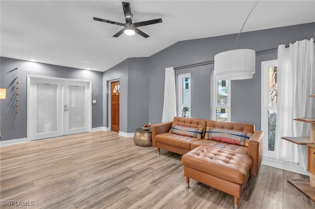 living room with ceiling fan, lofted ceiling, and light hardwood / wood-style floors