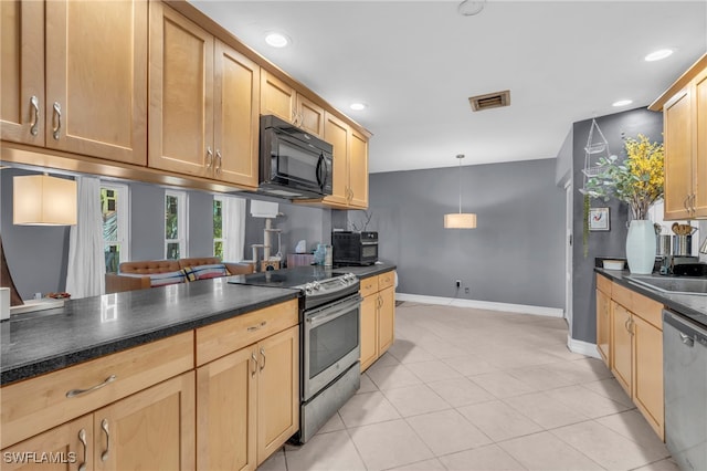 kitchen featuring sink, light tile patterned flooring, stainless steel appliances, and decorative light fixtures