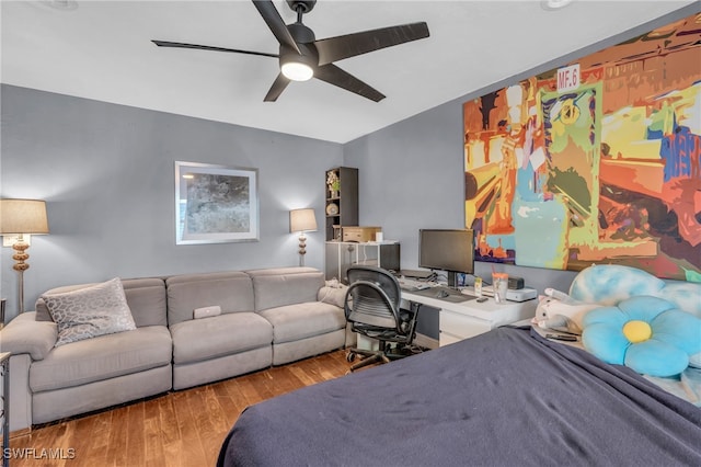 bedroom featuring light hardwood / wood-style flooring, ceiling fan, and built in desk