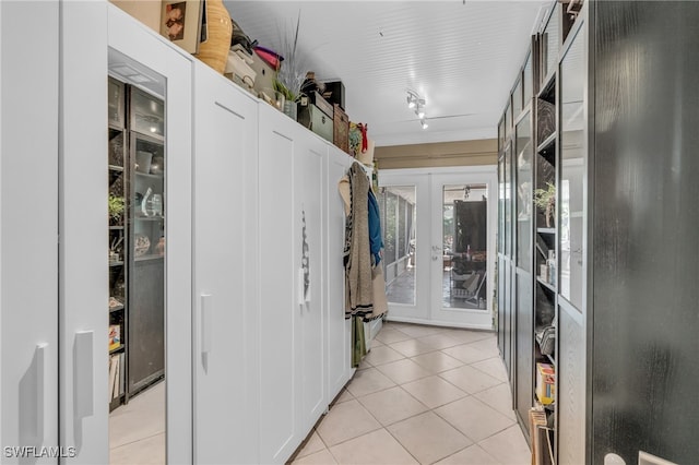 walk in closet featuring light tile patterned flooring and french doors