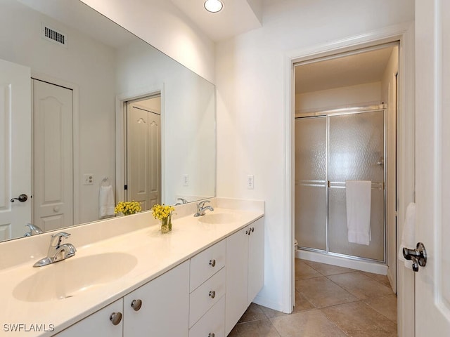 bathroom with tile patterned floors, vanity, and a shower with door