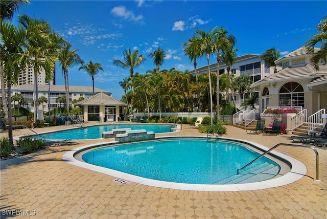 view of swimming pool with a patio and a hot tub