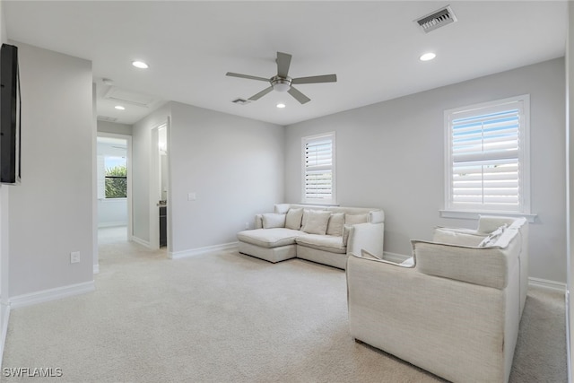 carpeted living room with ceiling fan and plenty of natural light