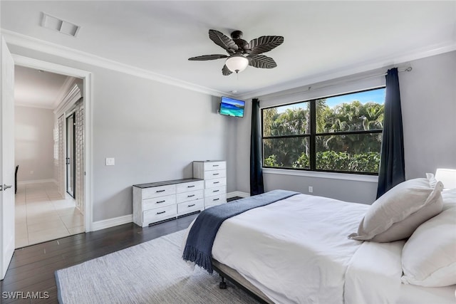 bedroom with baseboards, visible vents, a ceiling fan, ornamental molding, and dark wood-type flooring