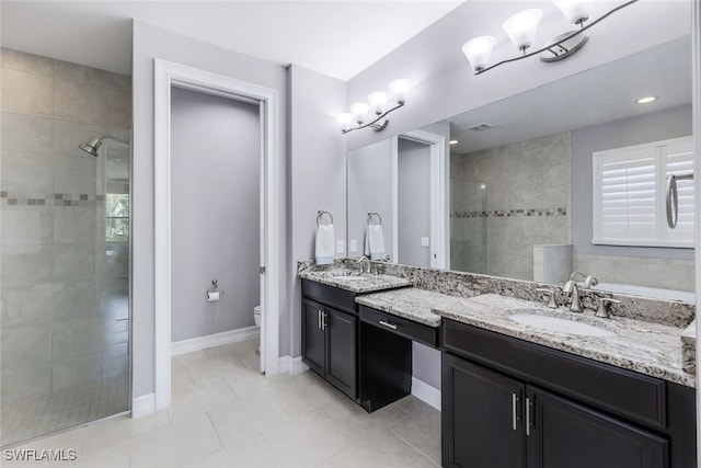 bathroom featuring tile patterned flooring, vanity, toilet, and tiled shower