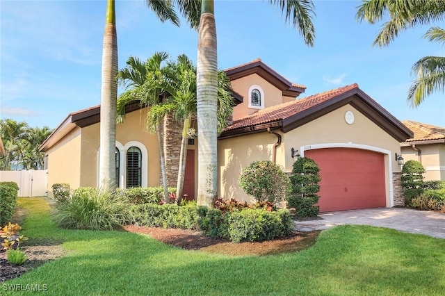 mediterranean / spanish house featuring a garage and a front lawn