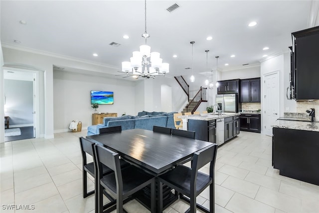 dining area featuring crown molding, stairway, visible vents, and an inviting chandelier