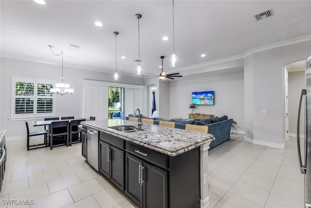 kitchen featuring an island with sink, plenty of natural light, and crown molding