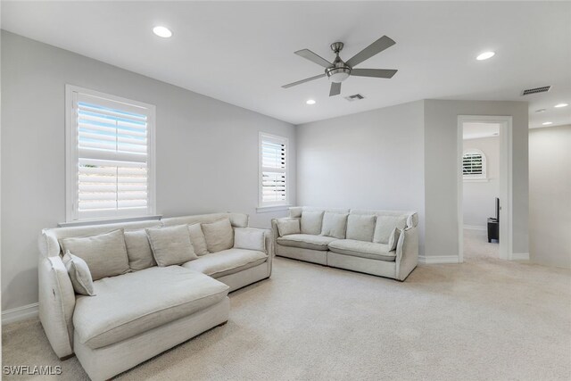 carpeted living room featuring ceiling fan and a healthy amount of sunlight