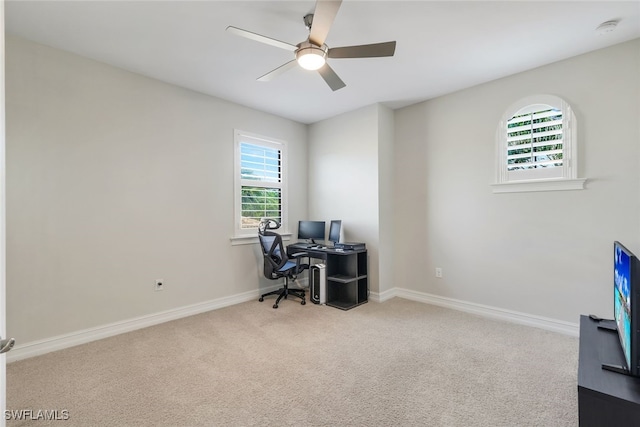 carpeted home office featuring ceiling fan