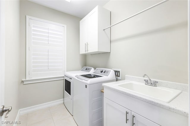 laundry area featuring washing machine and dryer, cabinets, sink, and light tile patterned flooring