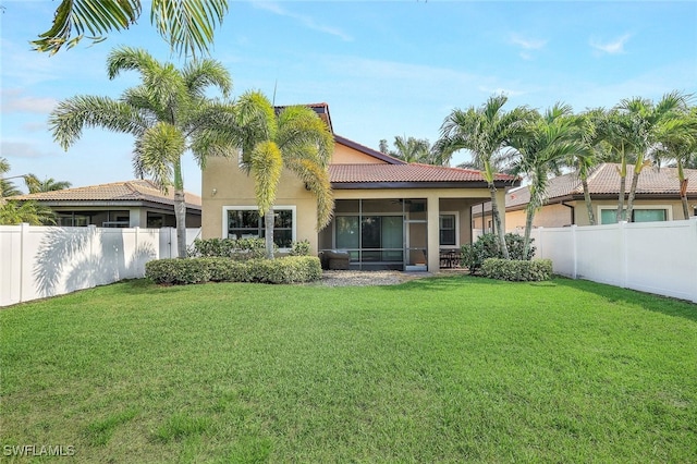 back of house with a sunroom, a fenced backyard, and a lawn