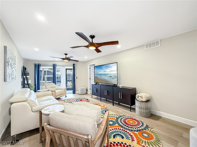 living room featuring ceiling fan and light hardwood / wood-style floors