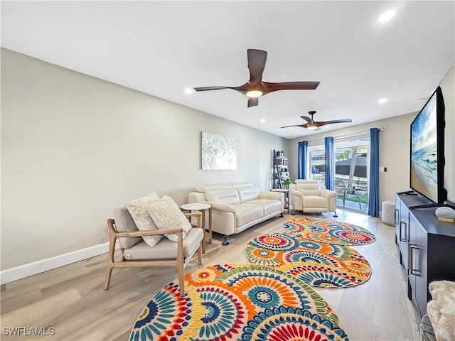 living room with light hardwood / wood-style floors and ceiling fan