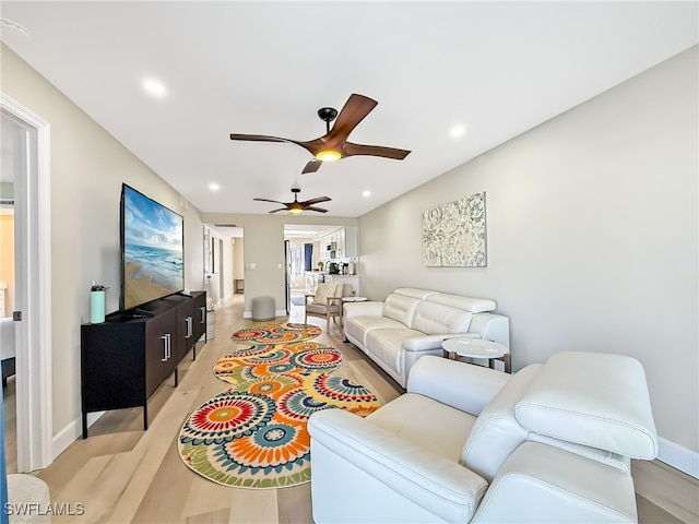 living room featuring ceiling fan and light wood-type flooring