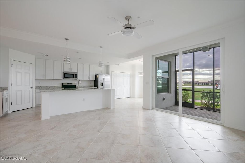 kitchen featuring white cabinetry, ceiling fan, decorative light fixtures, a kitchen island with sink, and appliances with stainless steel finishes