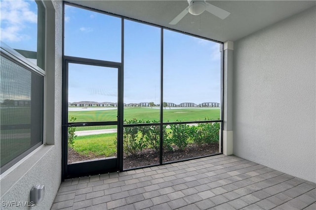 unfurnished sunroom with ceiling fan and plenty of natural light