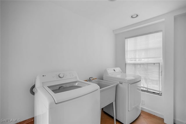 laundry area featuring sink, tile patterned floors, and washing machine and clothes dryer