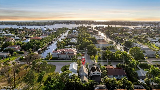 aerial view at dusk featuring a water view