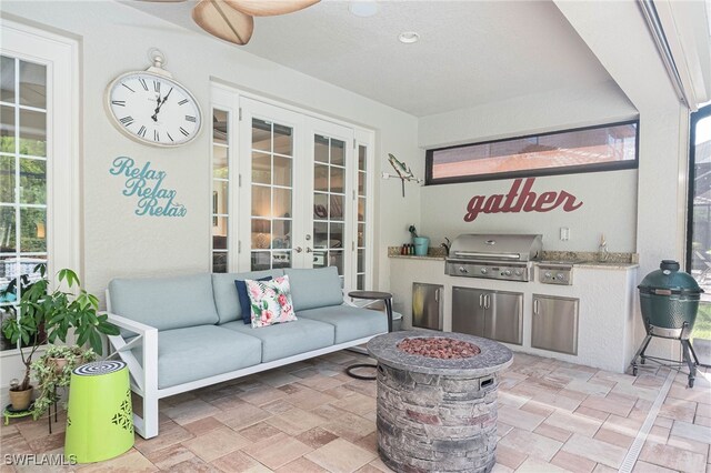 view of patio with french doors, an outdoor fire pit, and a grill