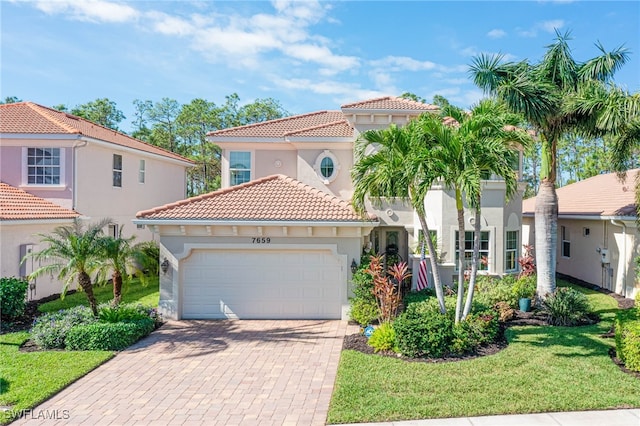 mediterranean / spanish home featuring a garage and a front lawn