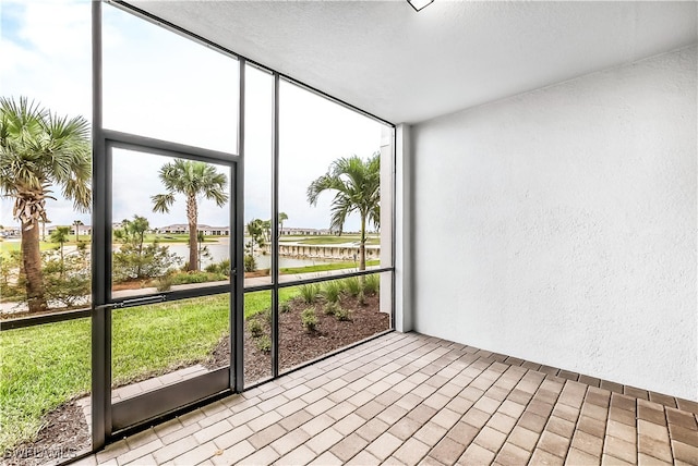 unfurnished sunroom featuring plenty of natural light and a water view