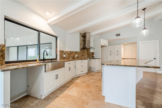 kitchen featuring white cabinetry, lofted ceiling with beams, wall chimney exhaust hood, and pendant lighting