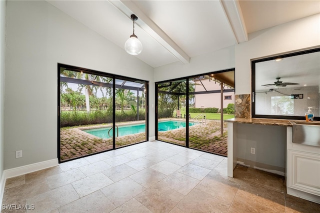 doorway with lofted ceiling with beams and ceiling fan