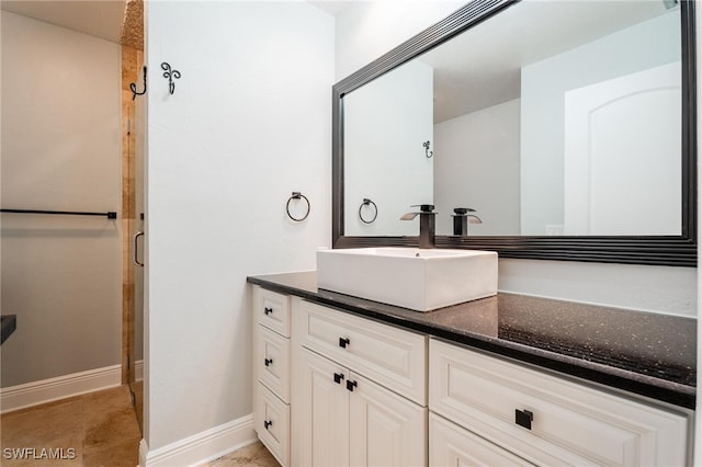 bathroom featuring tile patterned flooring, vanity, and a shower with door