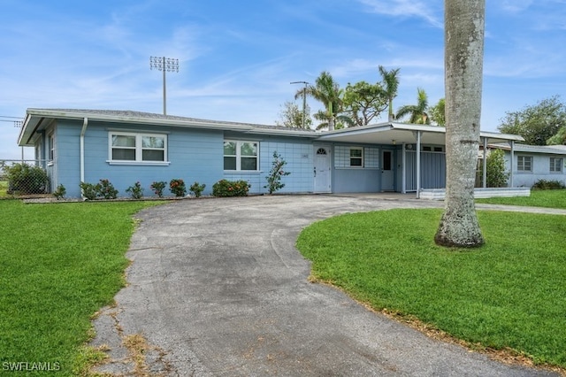 ranch-style house featuring a front lawn and a carport