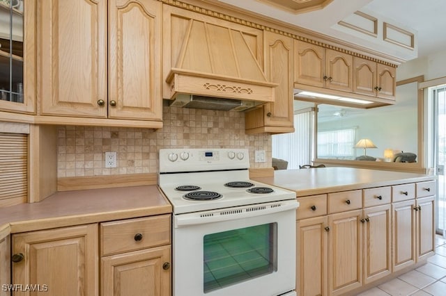 kitchen featuring light tile patterned flooring, tasteful backsplash, light brown cabinetry, custom exhaust hood, and white range with electric cooktop