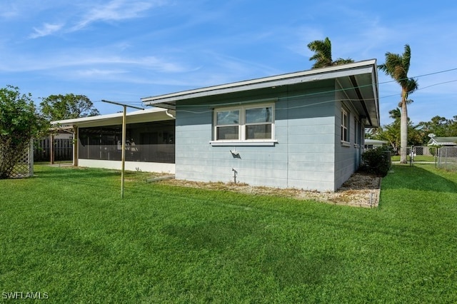 view of side of property with a sunroom and a yard