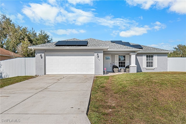 view of front of home featuring solar panels, a garage, and a front yard