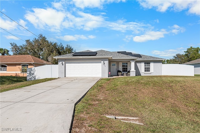 view of front facade with a front lawn, a garage, and solar panels