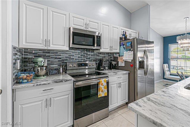 kitchen with stainless steel appliances, an inviting chandelier, white cabinets, decorative backsplash, and light tile patterned flooring