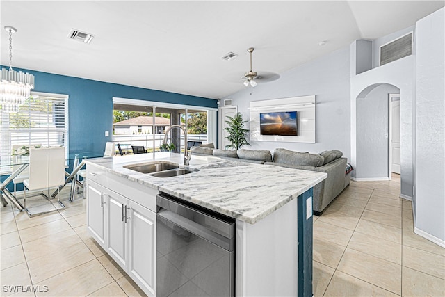 kitchen with lofted ceiling, sink, stainless steel dishwasher, an island with sink, and white cabinetry