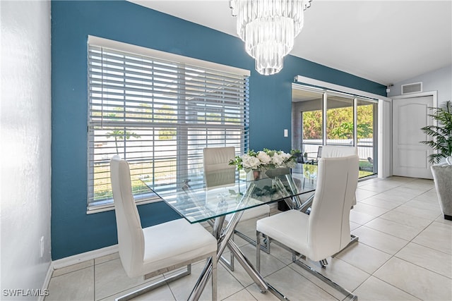 dining room with tile patterned flooring, vaulted ceiling, and a notable chandelier