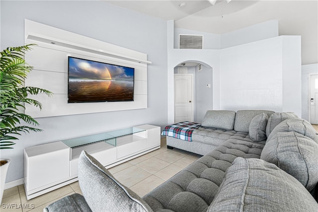 living room with ceiling fan, light tile patterned floors, and high vaulted ceiling