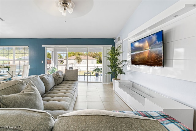 living room with ceiling fan, light tile patterned flooring, and lofted ceiling