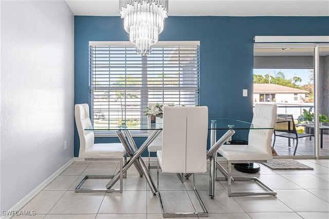 dining area featuring tile patterned floors and a chandelier