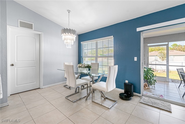 tiled dining area featuring an inviting chandelier and vaulted ceiling