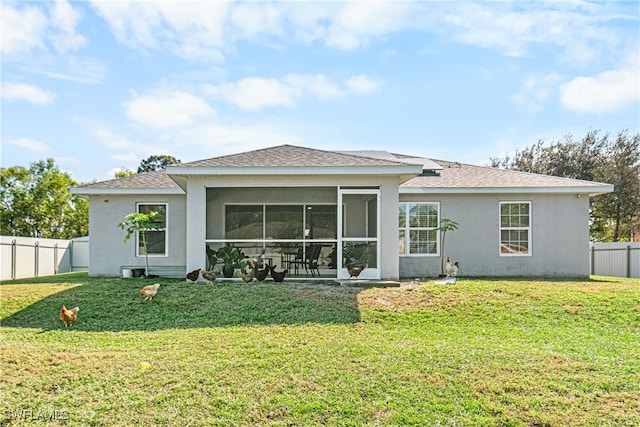 back of house with a lawn and a sunroom