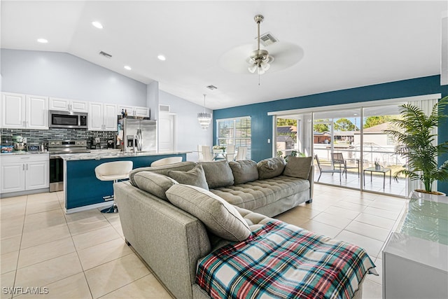 living room with vaulted ceiling, ceiling fan, and light tile patterned flooring