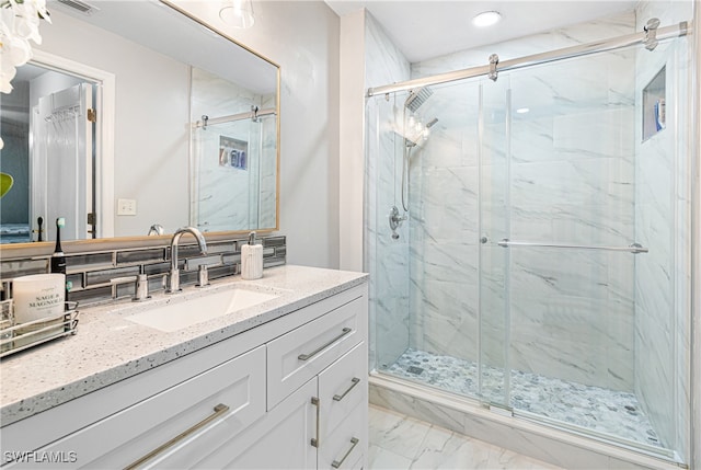 bathroom with vanity, tasteful backsplash, and an enclosed shower