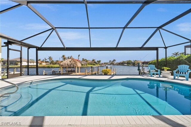 view of pool with a water view, a patio area, and glass enclosure